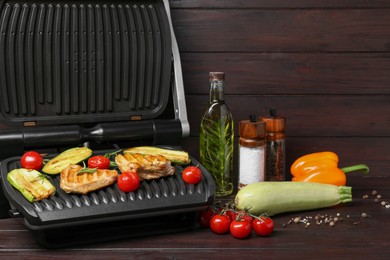 Electric grill with different products on wooden table