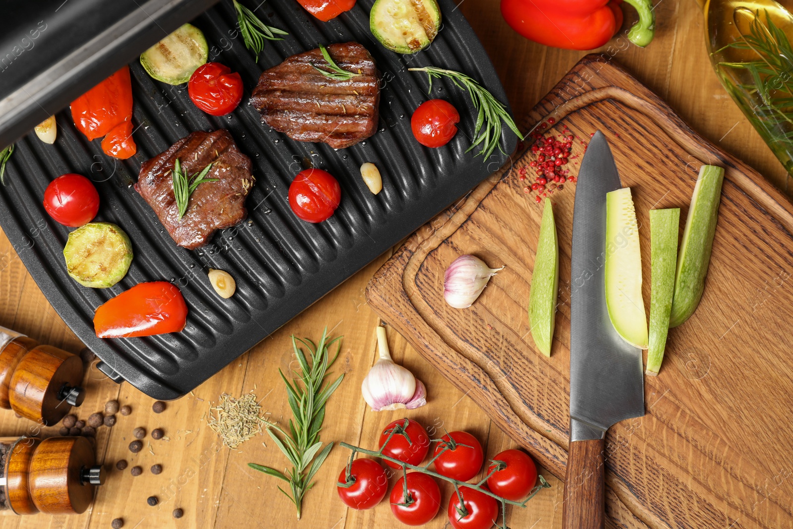 Photo of Flat lay composition with electric grill and different products on wooden table