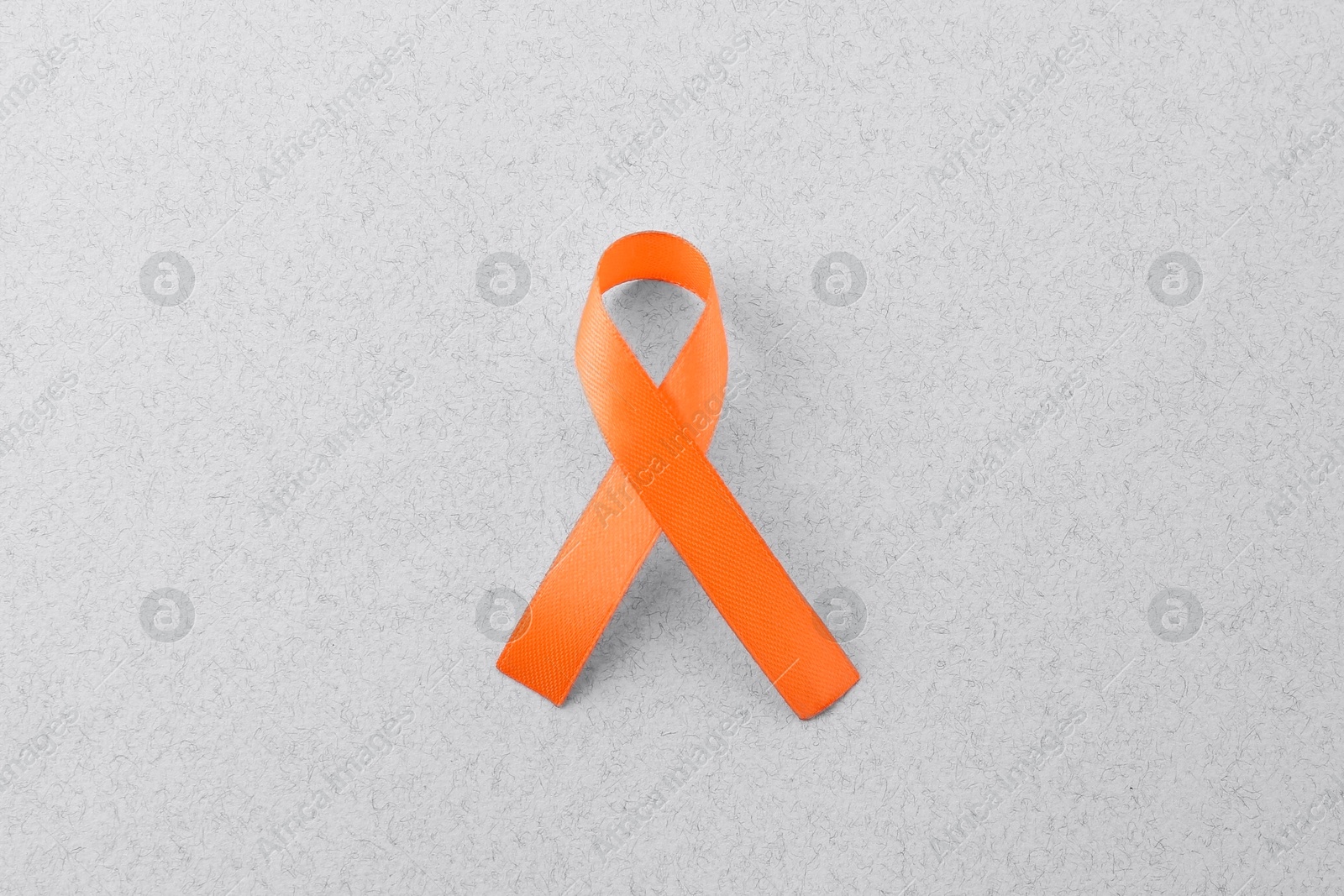 Photo of Orange awareness ribbon on gray background, top view