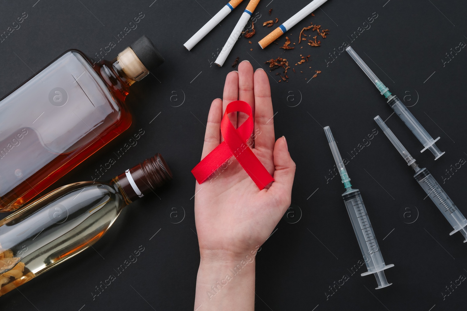 Photo of Woman with red awareness ribbon on black background, top view