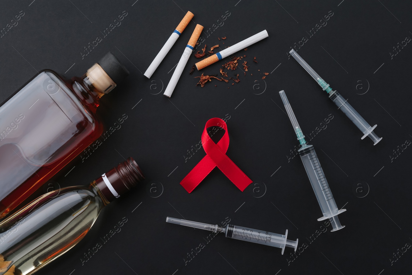 Photo of Flat lay composition with red awareness ribbon on black background