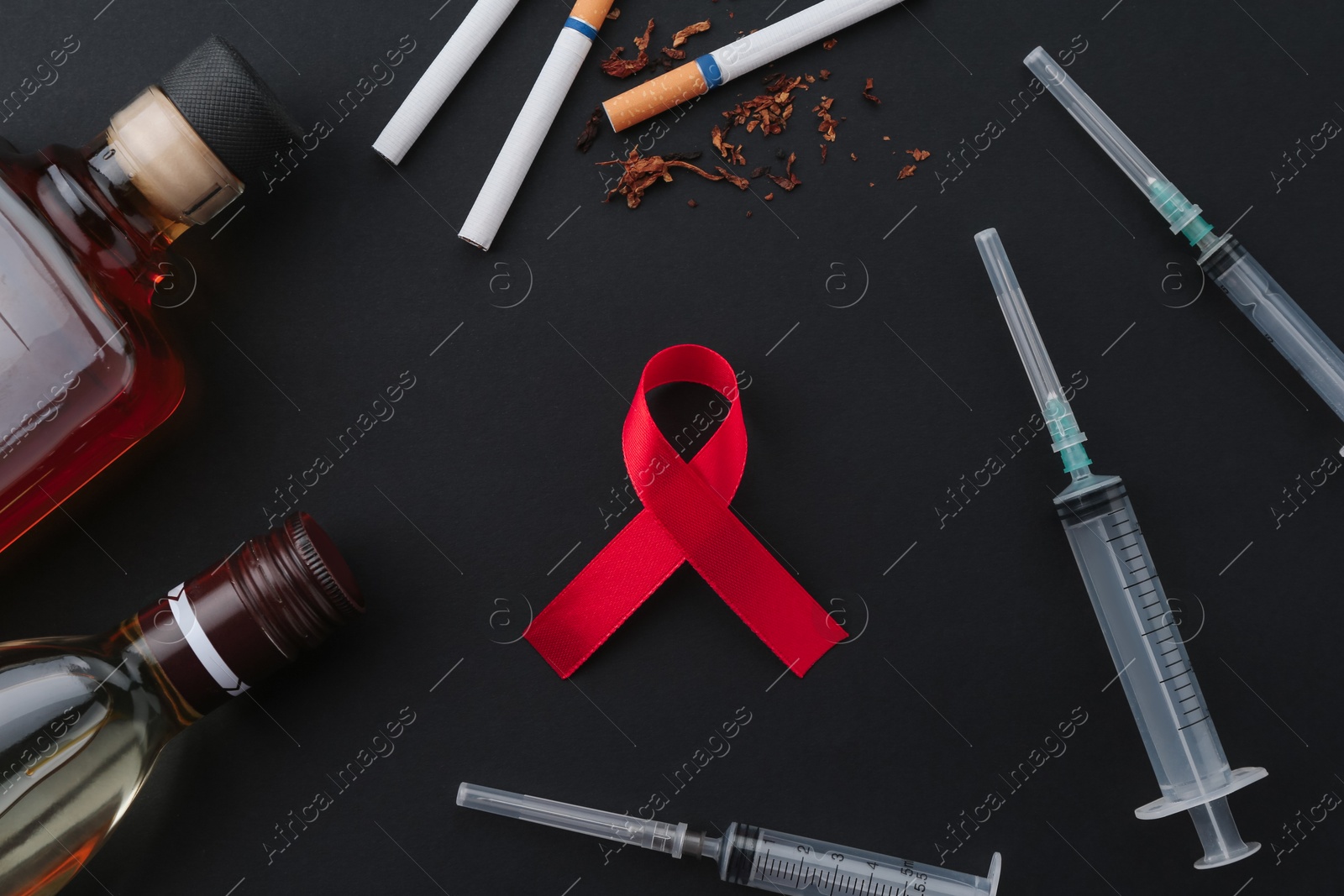 Photo of Flat lay composition with red awareness ribbon on black background