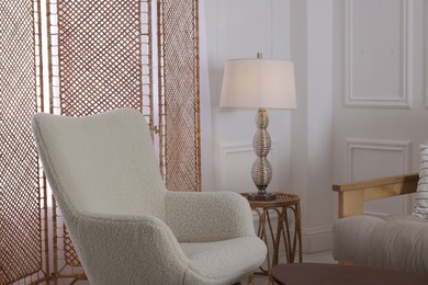 Folding screen, armchair and lamp in room