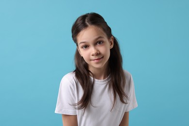 Photo of Portrait of beautiful girl on light blue background