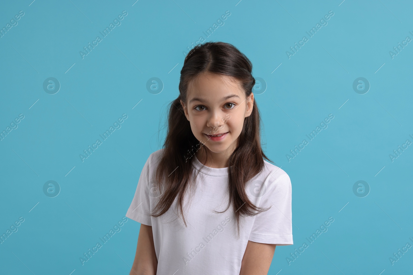 Photo of Portrait of beautiful girl on light blue background