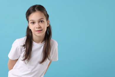 Photo of Portrait of beautiful girl on light blue background, space for text