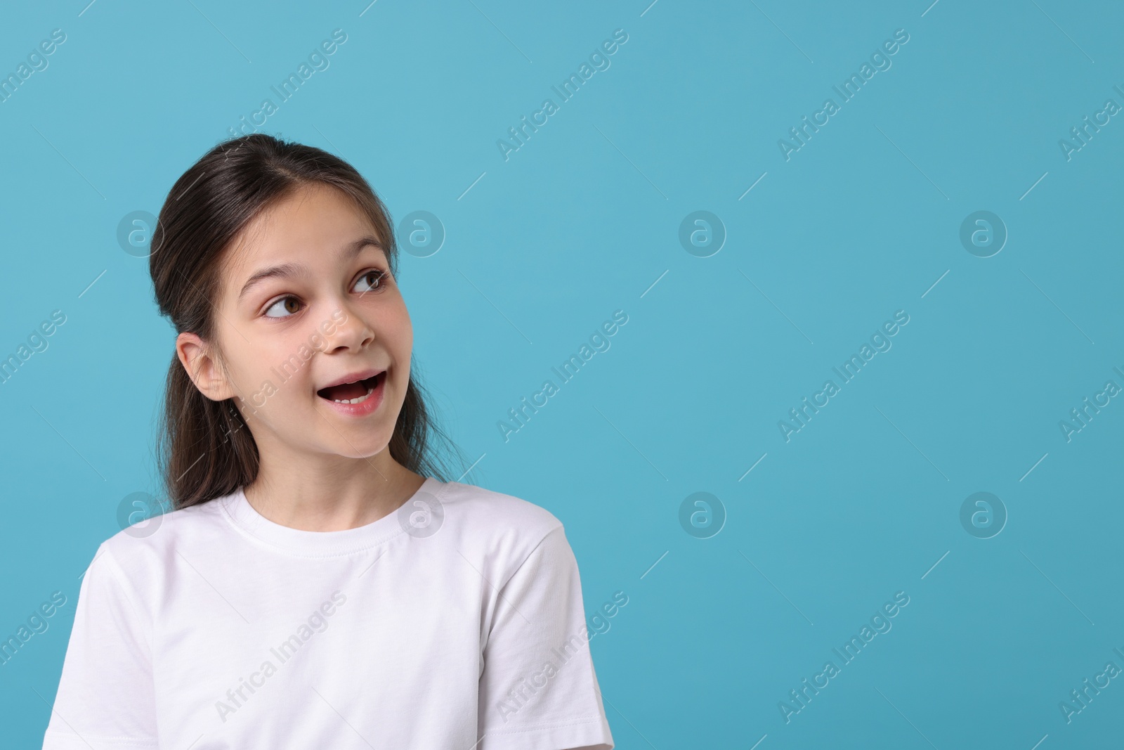 Photo of Portrait of emotional girl on light blue background, space for text