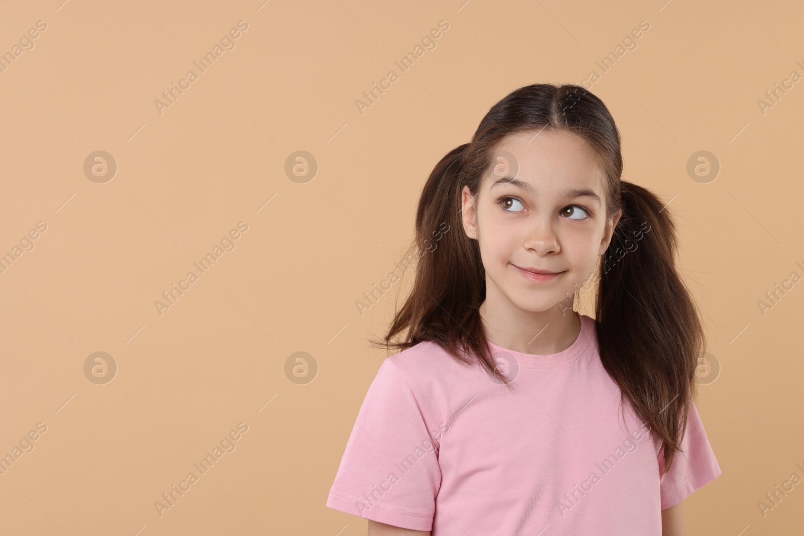 Photo of Portrait of beautiful girl on beige background, space for text