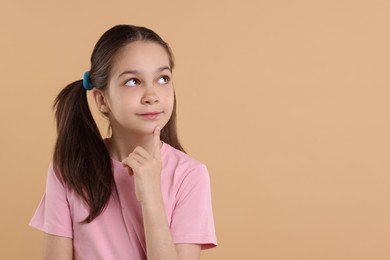 Portrait of beautiful girl on beige background, space for text