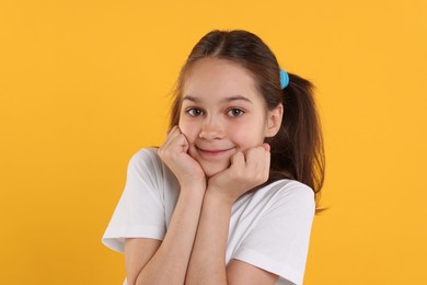 Photo of Portrait of beautiful girl on orange background