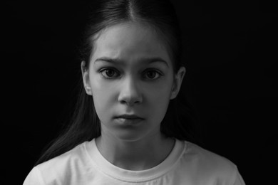 Portrait of sad girl in darkness, closeup. Black and white effect