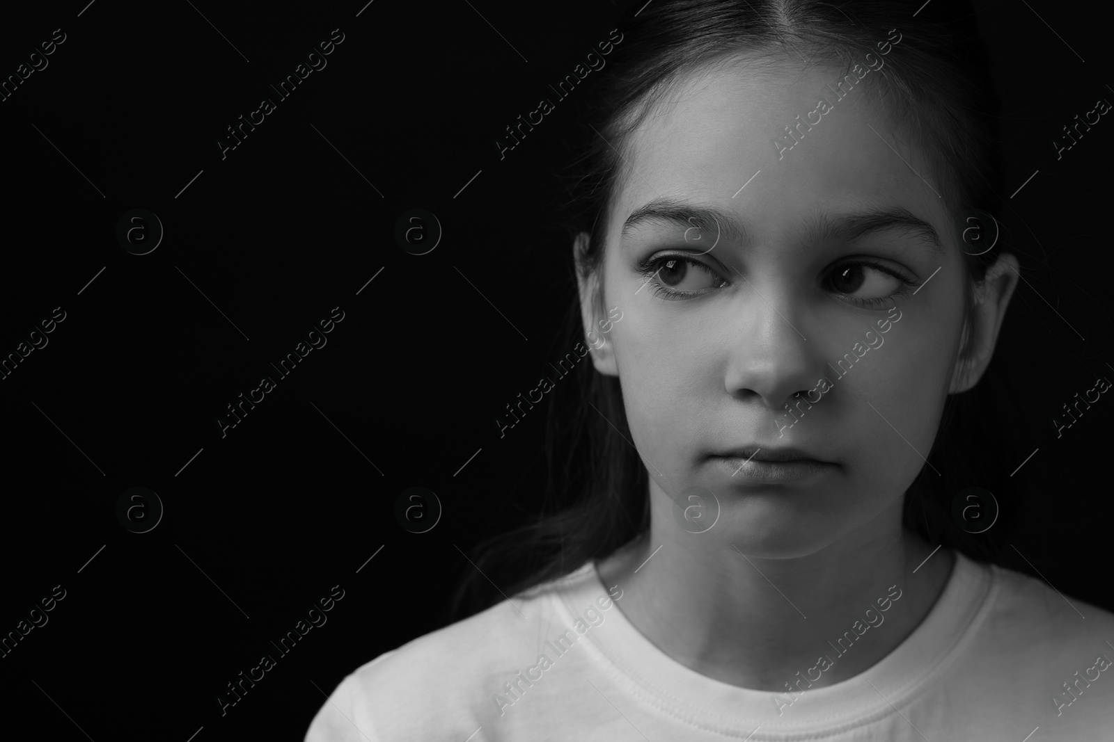 Photo of Portrait of sad girl on dark background, space for text. Black and white effect