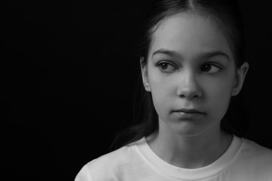 Photo of Portrait of sad girl on dark background, space for text. Black and white effect