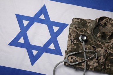 Photo of Stethoscope and military uniform on flag of Israel, top view