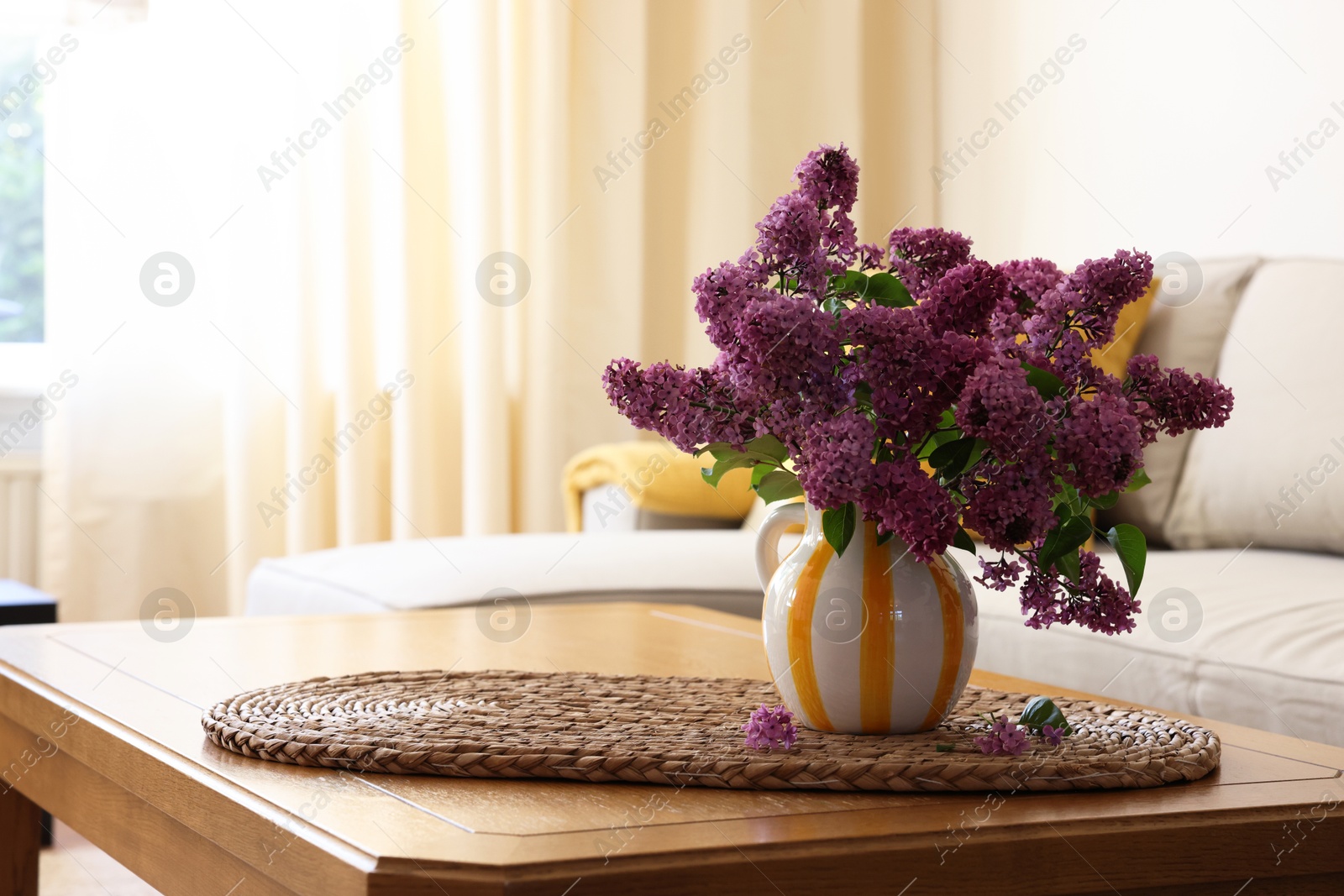 Photo of Beautiful fragrant lilac flowers in vase on table at home. Space for text