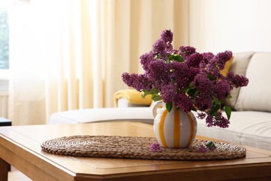 Photo of Beautiful fragrant lilac flowers in vase on table at home. Space for text