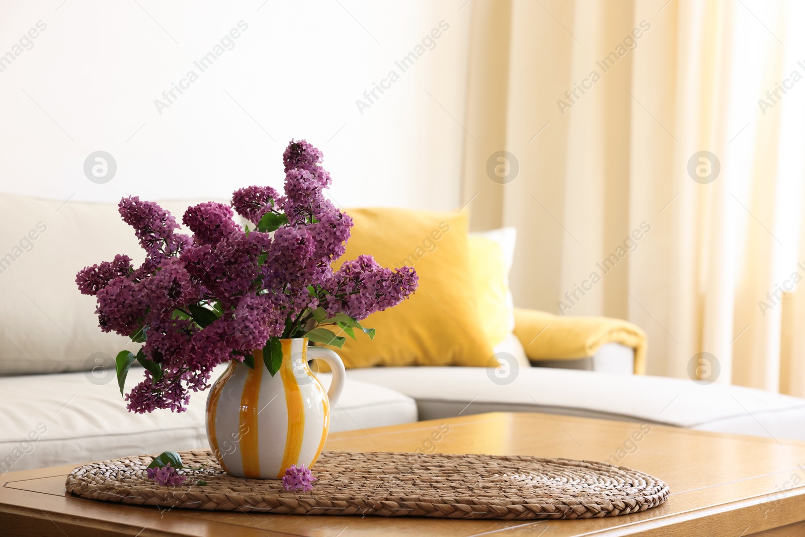 Photo of Beautiful fragrant lilac flowers in vase on table at home. Space for text