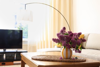 Photo of Beautiful fragrant lilac flowers in vase on table at home. Space for text