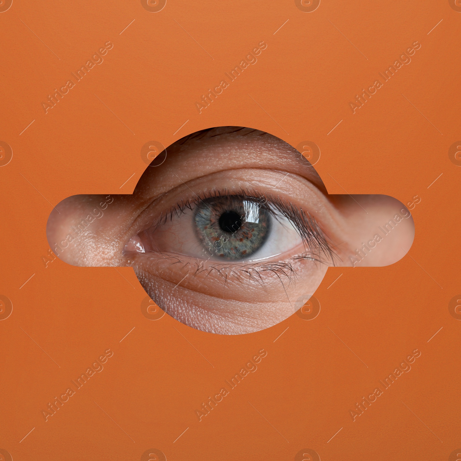 Image of Man looking through keyhole in orange surface