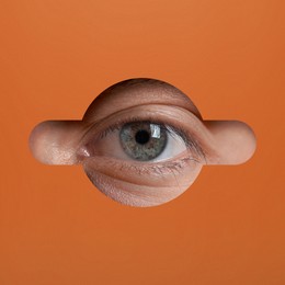 Image of Man looking through keyhole in orange surface