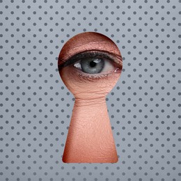 Image of Woman looking through keyhole in grey dotted surface