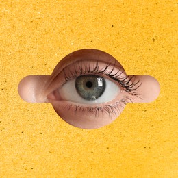 Woman looking through keyhole in yellow surface