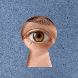 Woman looking through keyhole in blue surface