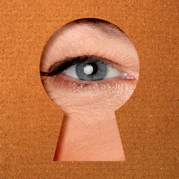 Image of Woman looking through keyhole in dark orange surface