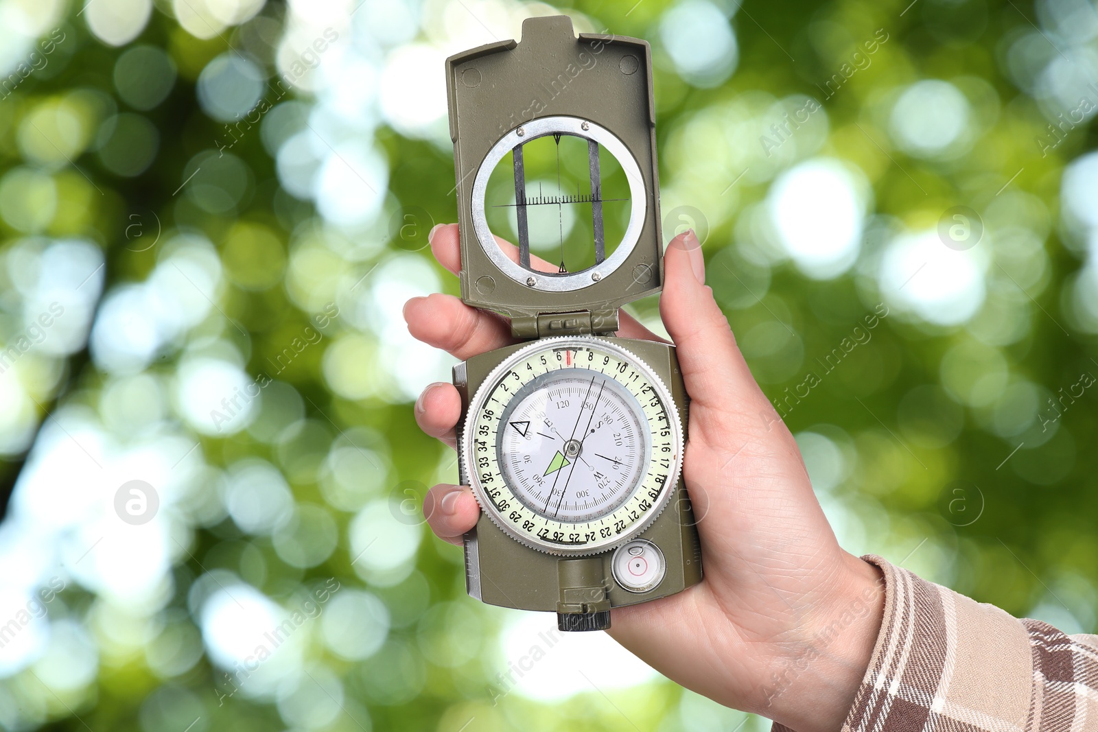 Image of Woman holding compass in nature, closeup. Navigational instrument