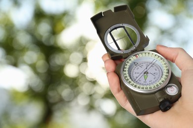 Image of Woman holding compass in nature, closeup. Navigational instrument