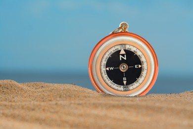 Image of Compass in sand, closeup. Space for text