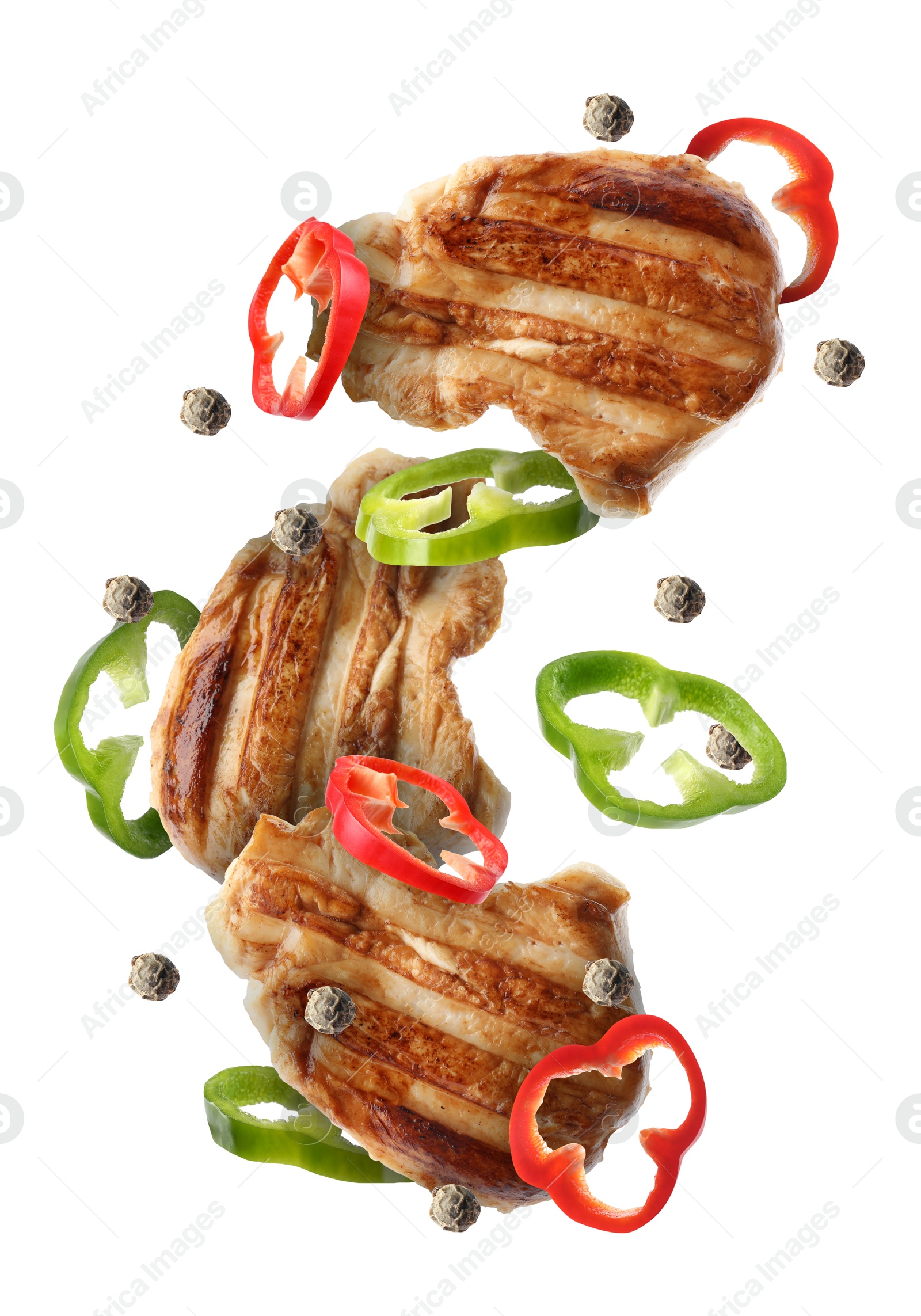 Image of Pieces of grilled chicken meat, pepper slices and peppercorns in air isolated on white