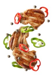 Image of Pieces of grilled chicken meat, pepper slices and peppercorns in air isolated on white