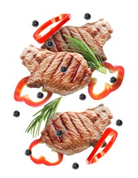 Image of Grilled steaks, pepper slices, rosemary and peppercorns in air isolated on white