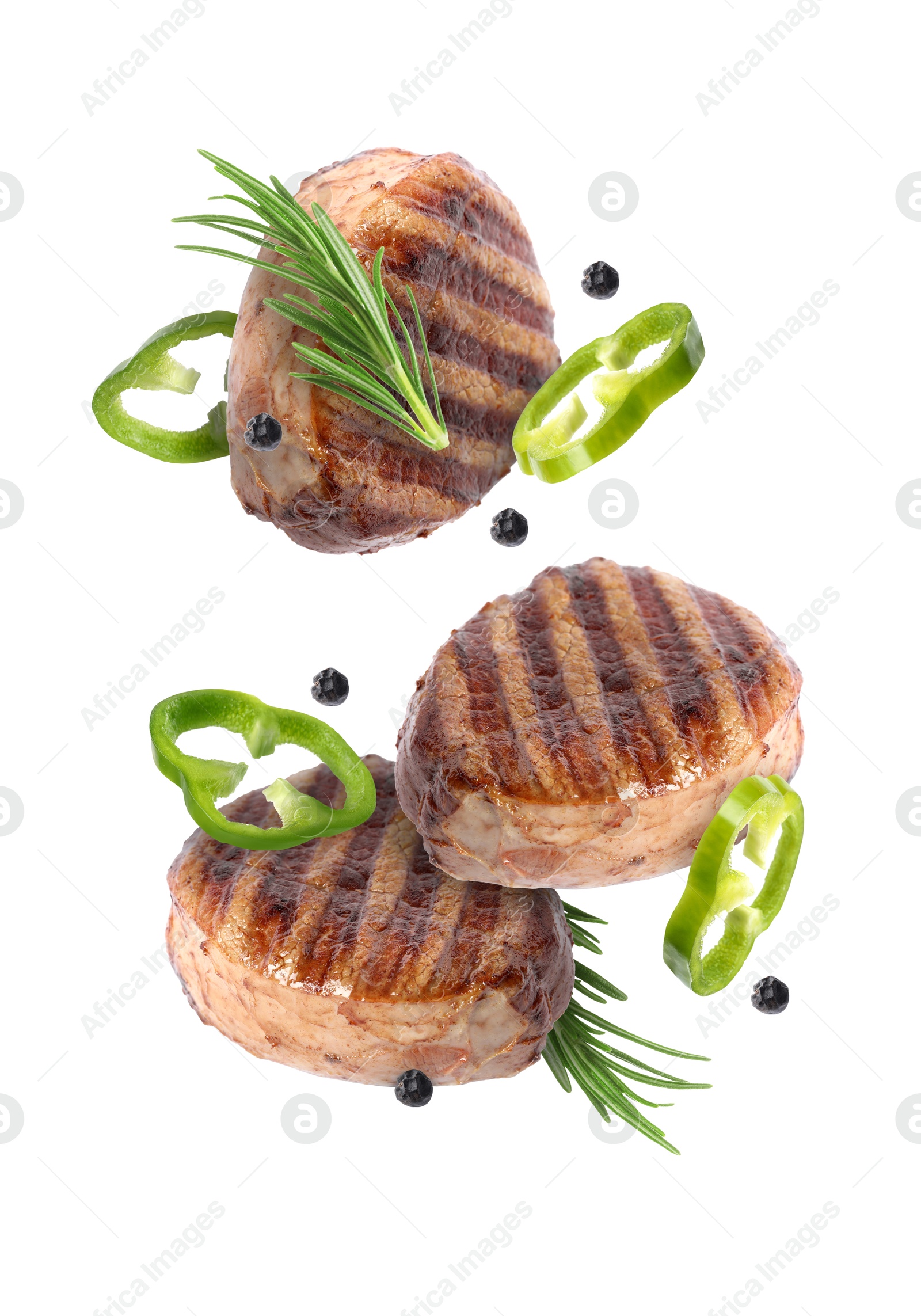 Image of Grilled beef medallions, pepper slices, rosemary and peppercorns in air isolated on white