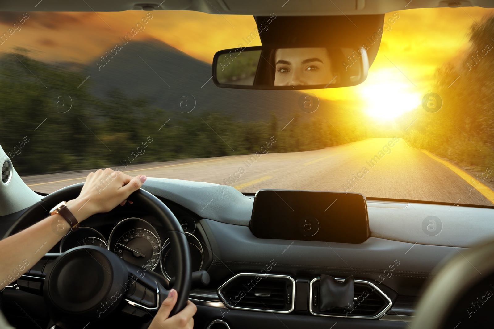 Image of Woman holding hands on steering wheel. Driving car