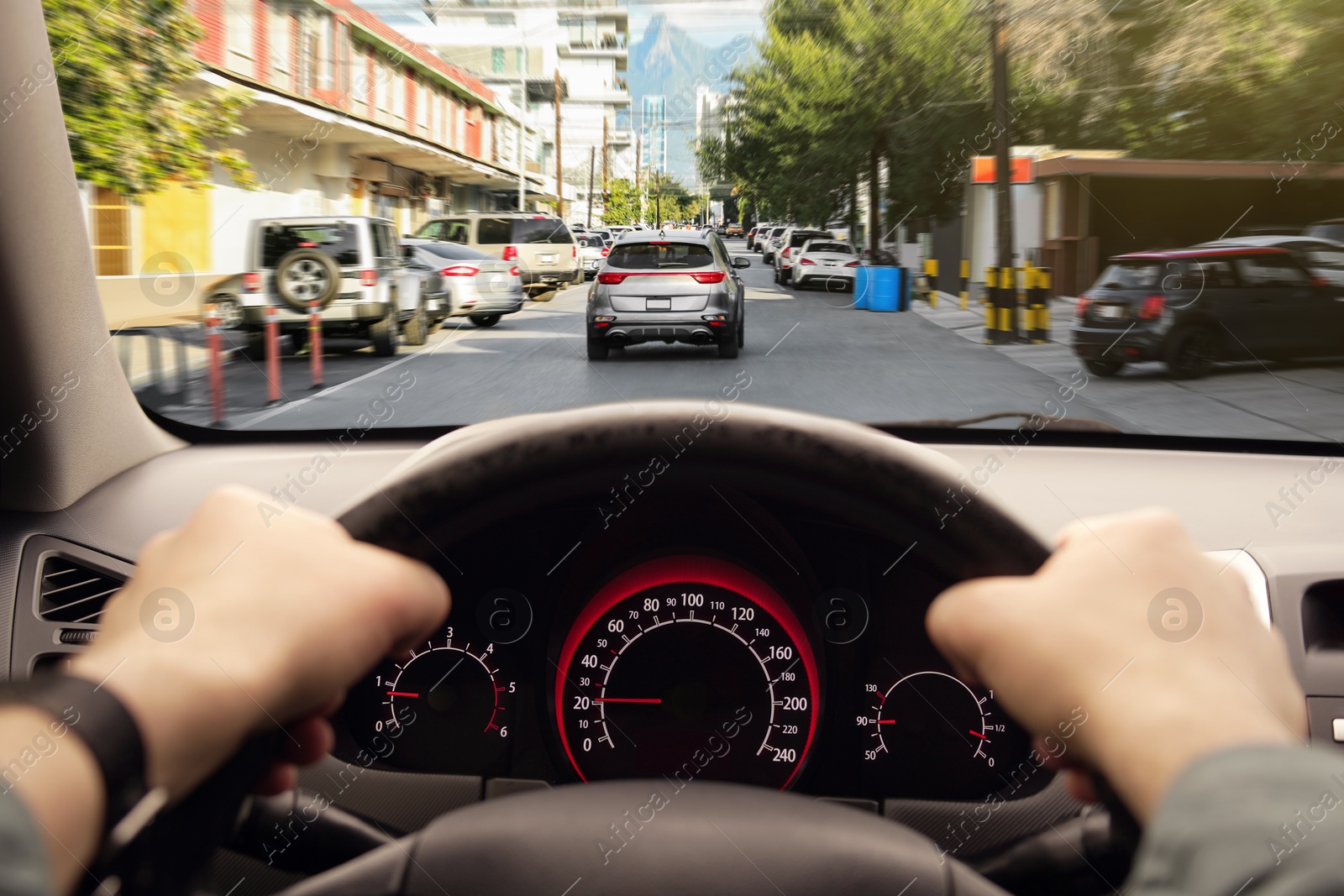 Image of Driving car, view from driver's seat. Man holding hands on steering wheel, closeup