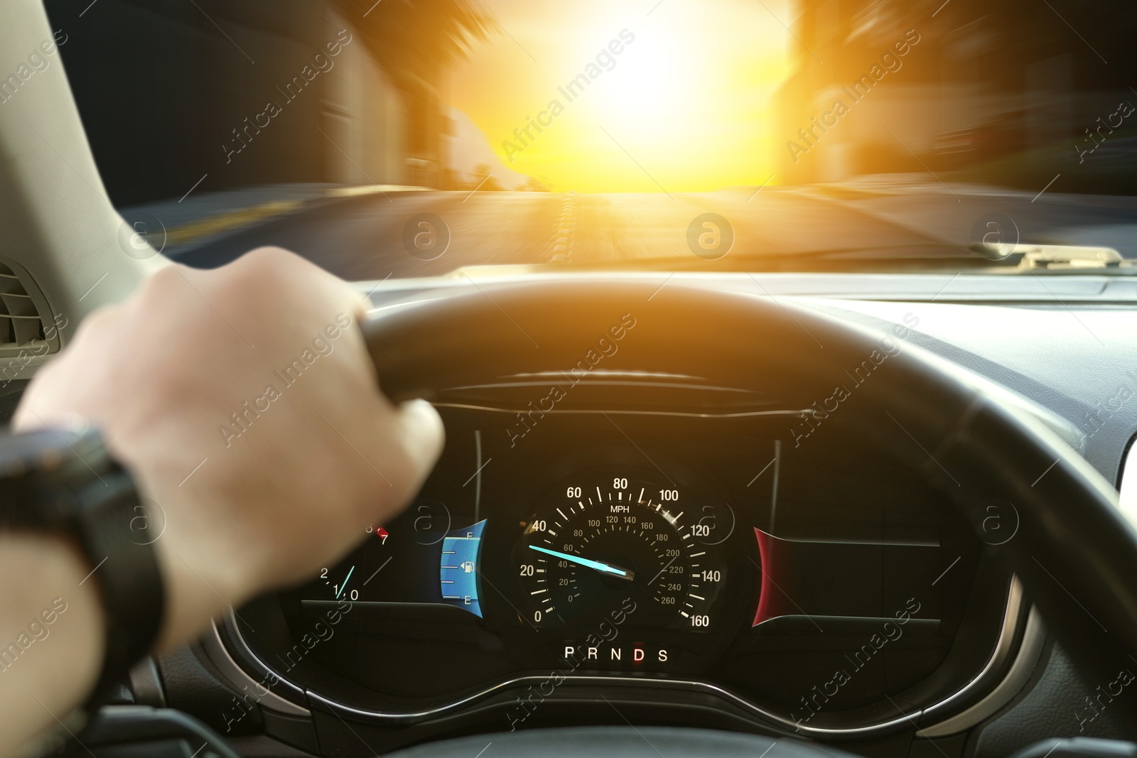 Image of Man driving car with one hand on steering wheel, closeup