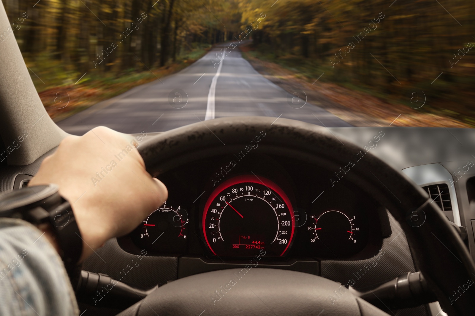 Image of Man driving car with one hand on steering wheel, closeup