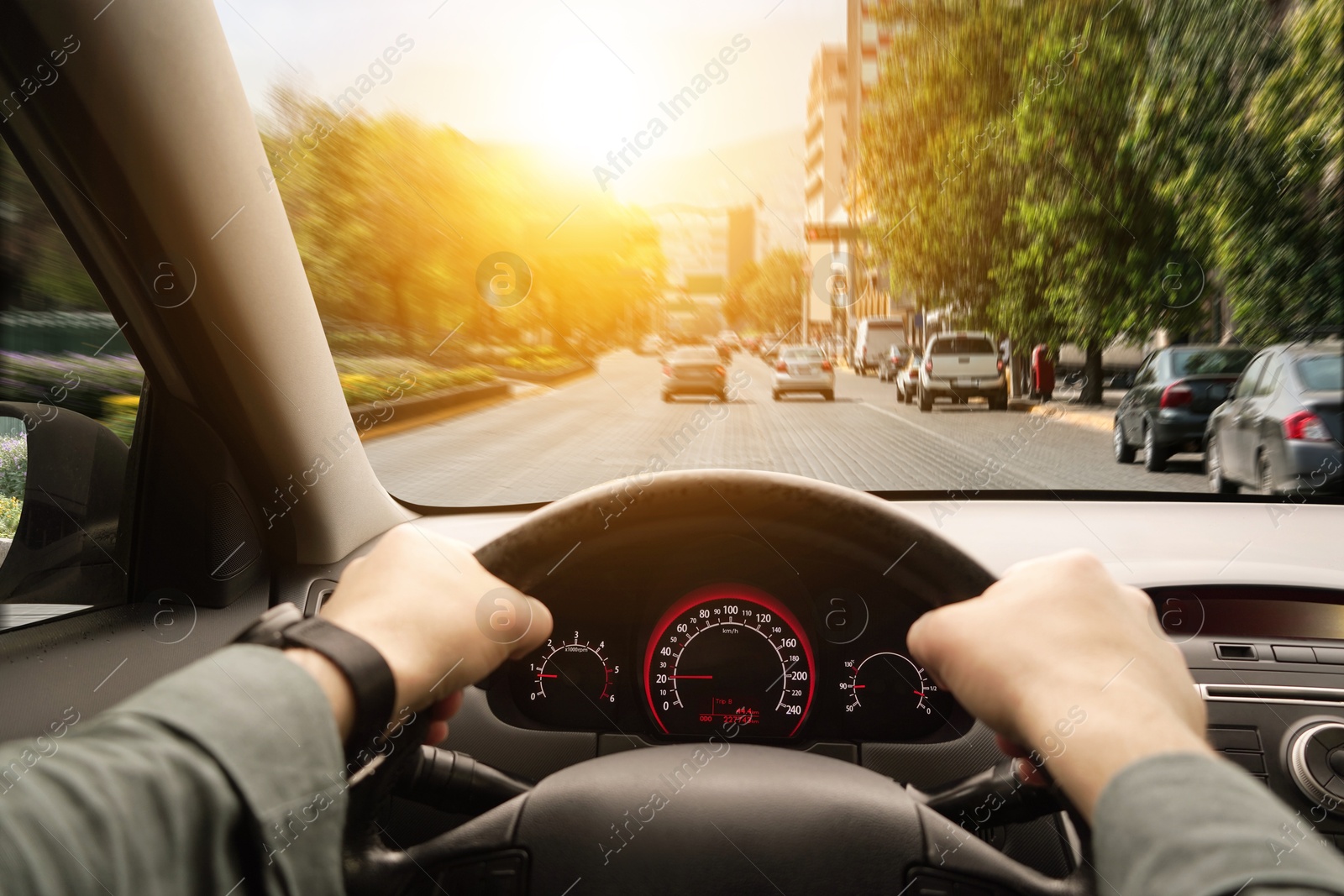 Image of Driving car, view from driver's seat. Man holding hands on steering wheel, closeup