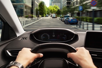 Image of Driving car, view from driver's seat. Man holding hands on steering wheel, closeup