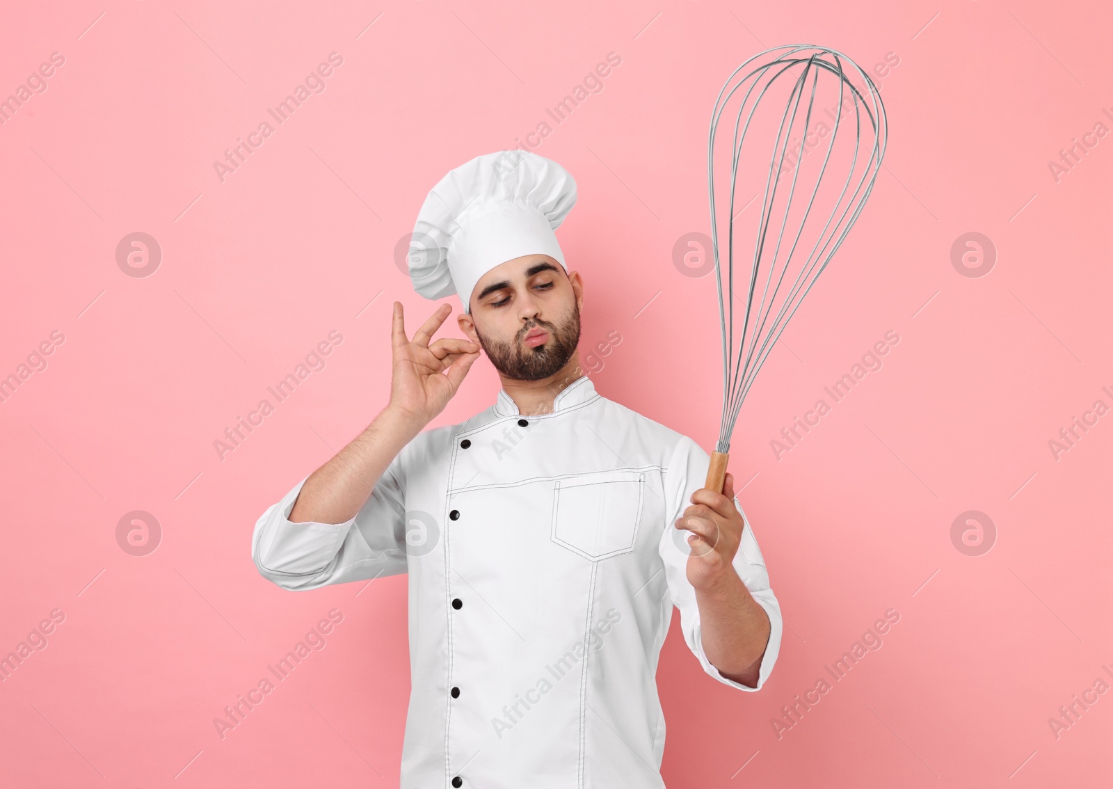 Image of Happy pastry chef with big whisk on pink background