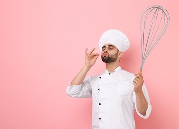 Image of Happy pastry chef with big whisk on pink background