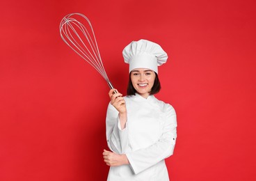 Happy pastry chef with big whisk on red background