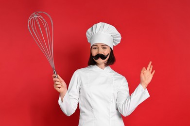 Pastry chef with fake mustache and big whisk on red background