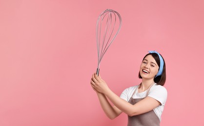Image of Happy pastry chef with big whisk on pink background. Banner design