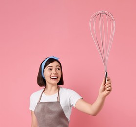 Happy pastry chef with big whisk on pink background