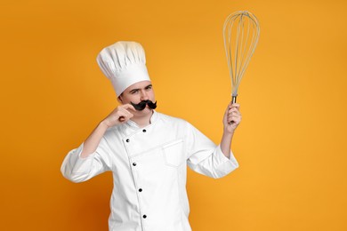 Pastry chef with fake mustache and big whisk on orange background