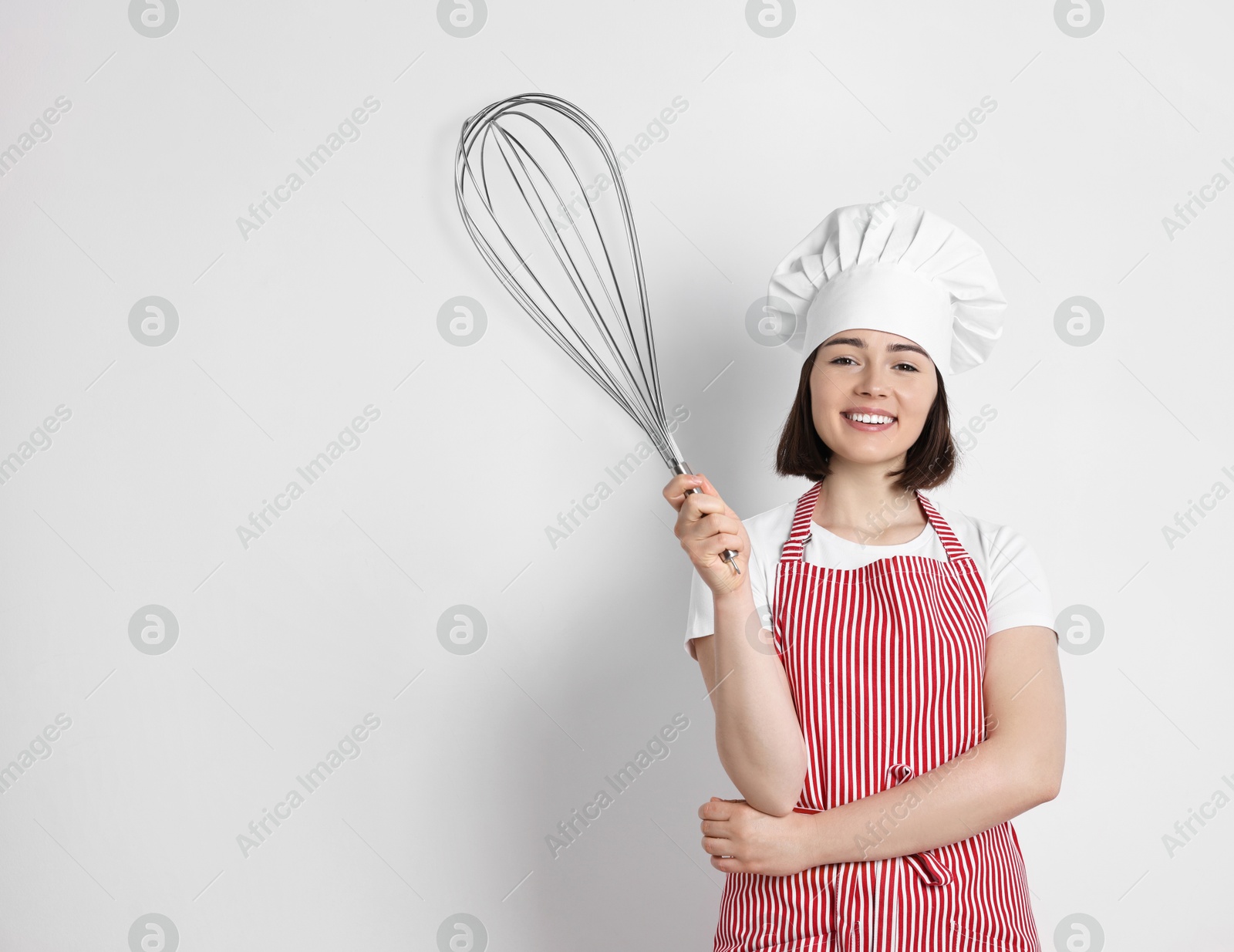 Image of Happy pastry chef with big whisk on light background