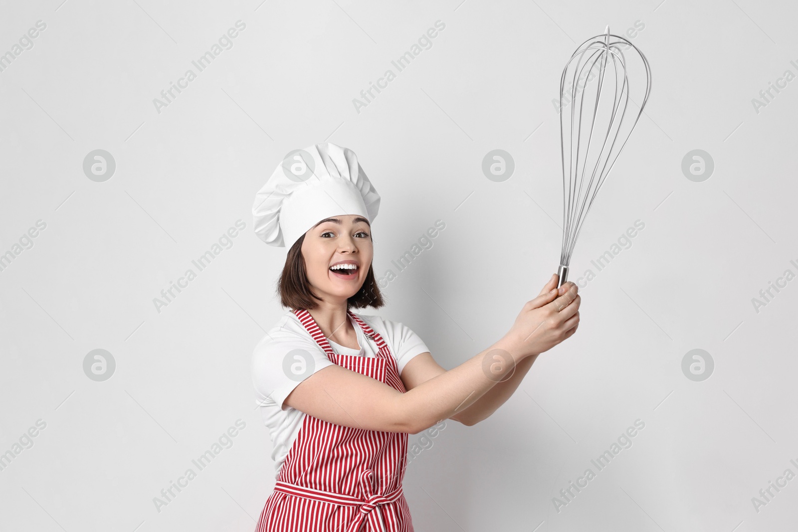 Image of Happy pastry chef with big whisk on light background